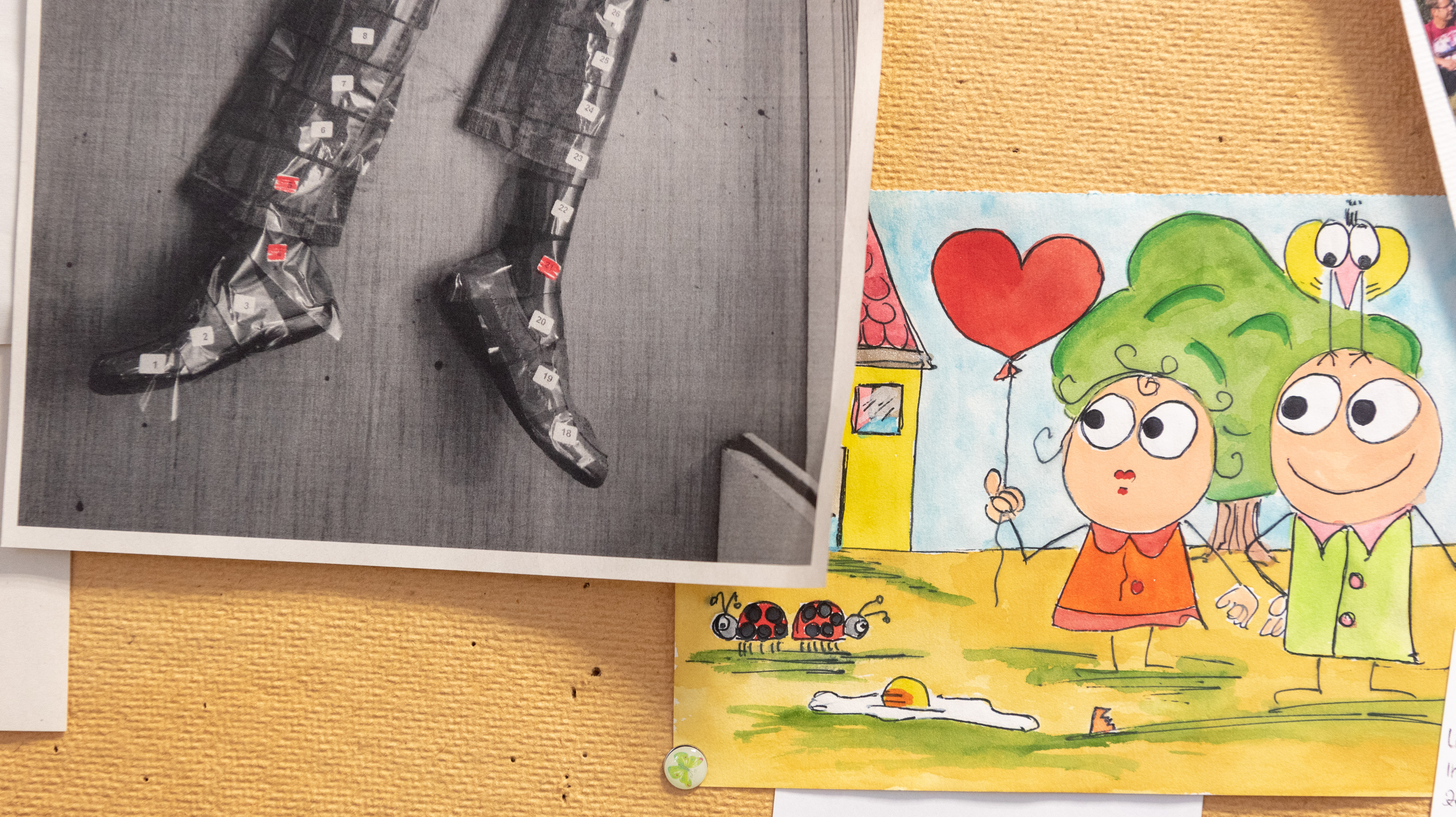 Neben Kinderzeichnungen hängen hier allerdings auch Fotos von Leichen an der Wand.