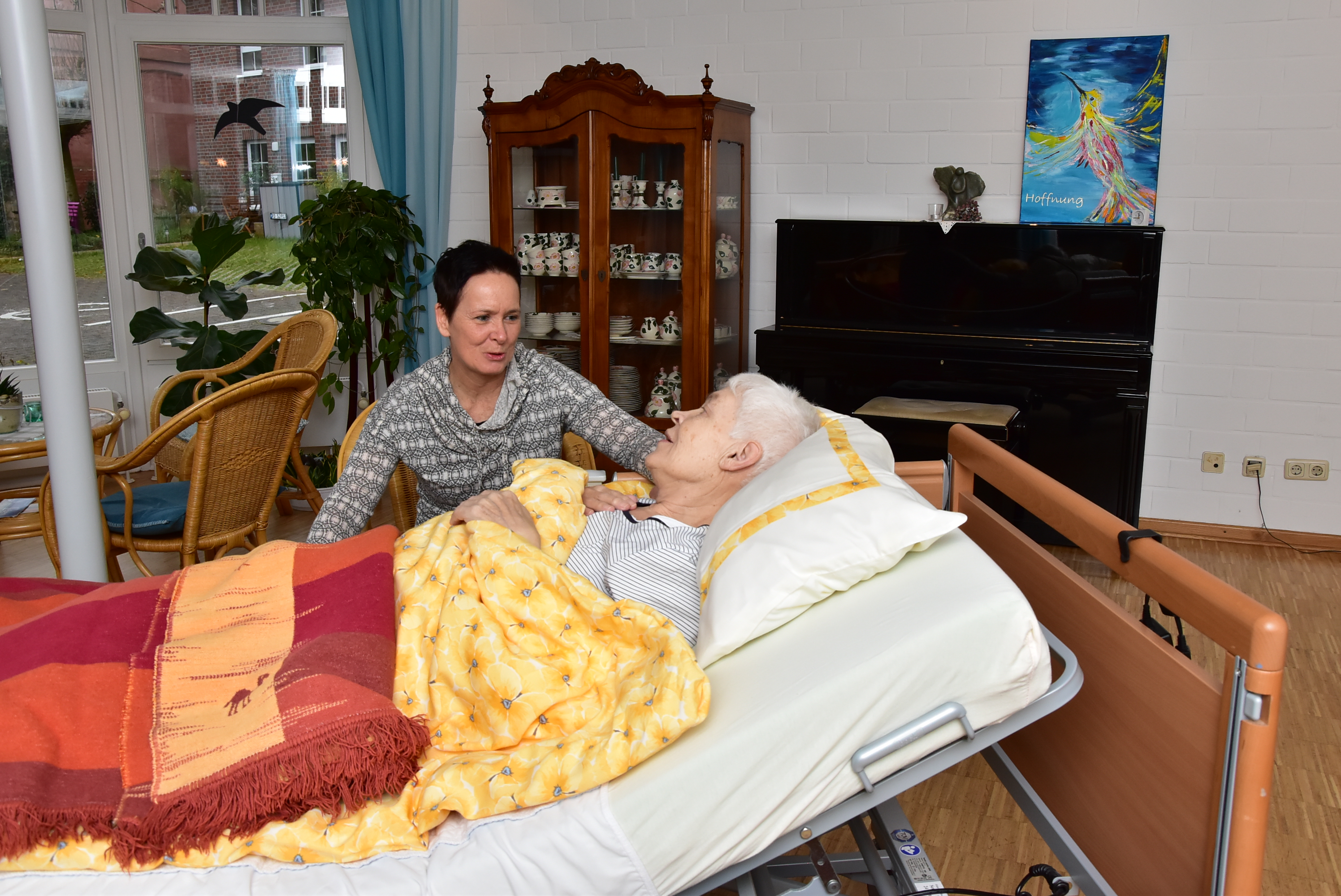 Michaela Mehlmann, stellvertretende Leiterin des Hauses Porsefeld, kümmert sich im Wintergarten des Hospizes um eine Bewohnerin.